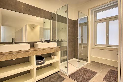 uma casa de banho com 2 lavatórios e uma cabina de duche em vidro. em MyPlaceLisbon - Luxury Trindade I em Lisboa