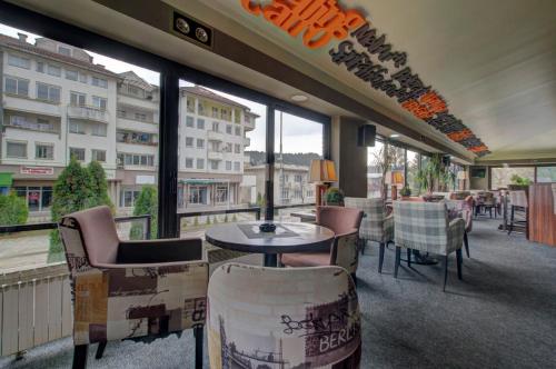 a restaurant with a balcony with tables and chairs at Hotel Zlatna Žita in Pale
