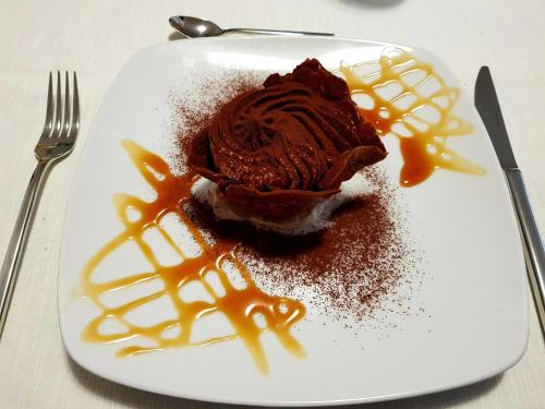 a chocolate dessert on a white plate with caramel sauce at Hotel La Sorgente in Savelletri di Fasano