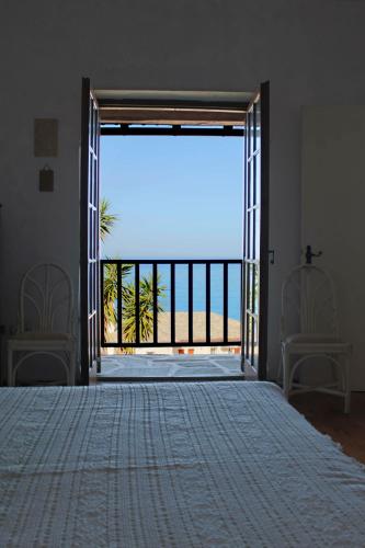 a bedroom with a bed and a view of the ocean at Panagopoulos House in Agios Ioannis Pelio