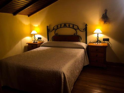 sypialnia z łóżkiem i 2 szafkami nocnymi z lampkami w obiekcie La Era w mieście Lario