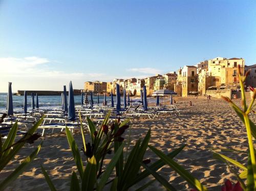 a beach with chairs and umbrellas and the ocean at Garibaldi B&B in Cefalù