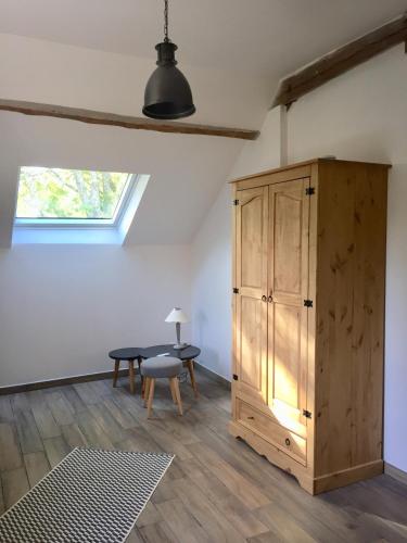 Cette chambre comprend une armoire en bois et une table. dans l'établissement Chambres d'hôtes Au Coeur De Lolhm, au Buisson de Cadouin