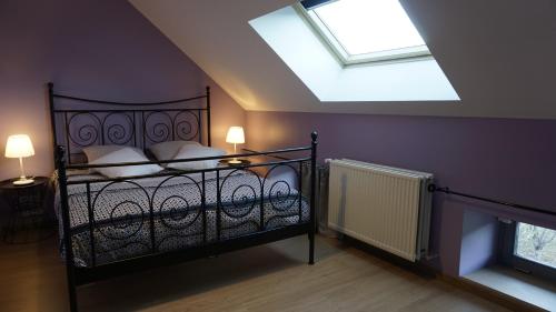 a bedroom with a black bed with a skylight at Gîte Le Tournesac in Saint-Didier