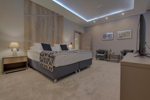 a bedroom with a bed and a desk and a television at Hotel Zlatna Žita in Pale