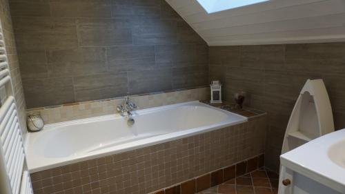 a large bath tub in a bathroom with a window at Gîte Le Tournesac in Saint-Didier