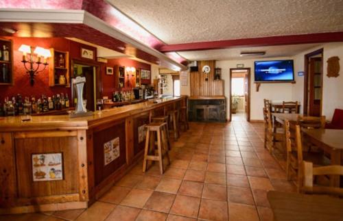 a bar in a restaurant with tables and chairs at La Era in Lario