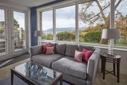 a living room with a couch and a large window at The Samling Hotel in Windermere