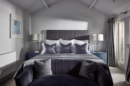 um quarto com uma cama grande e almofadas em The Samling Hotel em Windermere