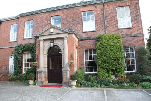 a red brick building with a black door at Dovecliff Hall Hotel in Burton upon Trent