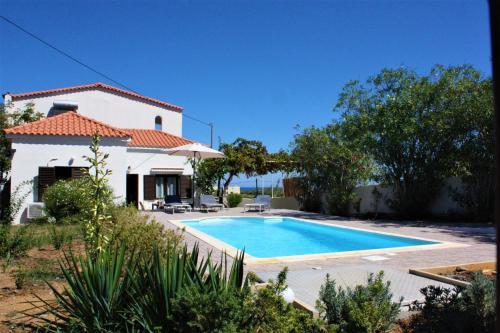 a villa with a swimming pool in front of a house at Casa Skouteli with Private pool in Kolymvari