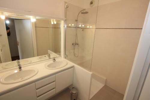 une salle de bain blanche avec deux lavabos et une douche dans l'établissement App 3 pièces hyper proche Disney, refait à neuf, à Serris