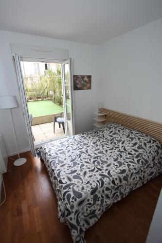 une chambre avec un lit et une porte coulissante en verre dans l'établissement App 3 pièces hyper proche Disney, refait à neuf, à Serris