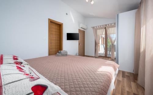 a bedroom with a large bed and a television at House Smoky with private pool and jacuzzi in Pazin