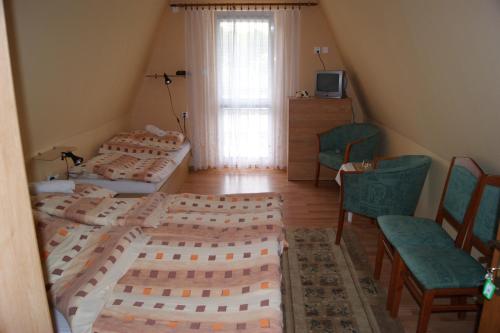 1 Schlafzimmer mit 2 Betten, einem Tisch und Stühlen in der Unterkunft Penzión Koruna in Nitrianske Rudno