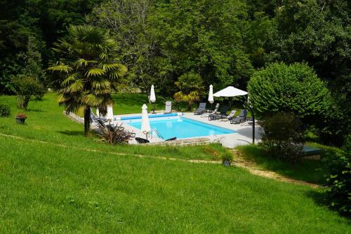 - une piscine dans une cour à côté d'une pelouse dans l'établissement Chambres d'hôtes Au Coeur De Lolhm, au Buisson de Cadouin