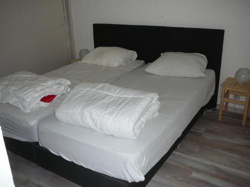 two twin beds with white sheets and pillows at Strandslag Zanddijk 229 Julianadorp aan Zee in Julianadorp