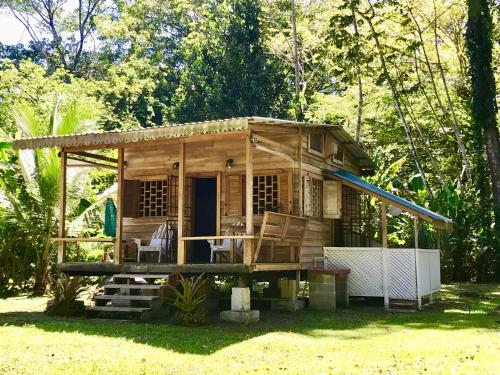 una pequeña casa de madera con porche en Villa Mar, en Puerto Viejo
