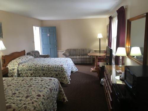 una camera d'albergo con due letti e una televisione di Catamount Motel a Bennington