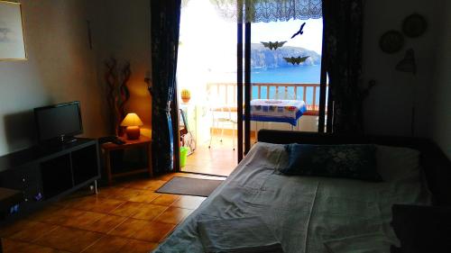 ロス・クリスティアーノスにあるOcean view over Los Cristianos, Playa las Vistas, WiFiのベッドルーム1室(ベッド1台付)、バルコニーへのドアが備わります。