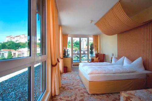 Cette chambre comprend un lit et une grande fenêtre. dans l'établissement Hotel Burgblick, à Hochburg-Ach