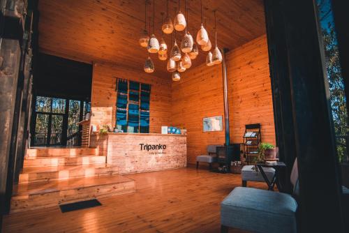 Tripanko Lodge & Bungalows في بتشيلمو: غرفة معيشة بجدران خشبية وأرضية خشبية