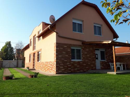 dom z trawnikiem przed nim w obiekcie Sunshine Apartment w Hajduszoboszlo