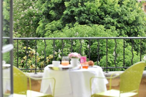 a table with a white table cloth and flowers on a balcony at La Maison d'Aix in Aix-en-Provence