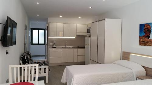 a small bedroom with two beds and a kitchen at CARPE DIEM in Puerto de la Cruz