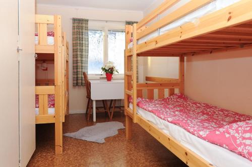 a bedroom with two bunk beds and a desk at Källviken Semesterby in Strömstad