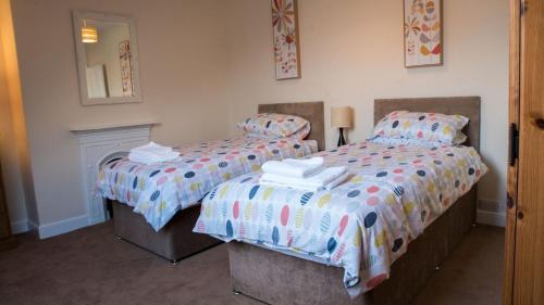Un dormitorio con dos camas y un espejo. en Kittiwake Number 4 - Town Centre & Spacious, en Bridlington