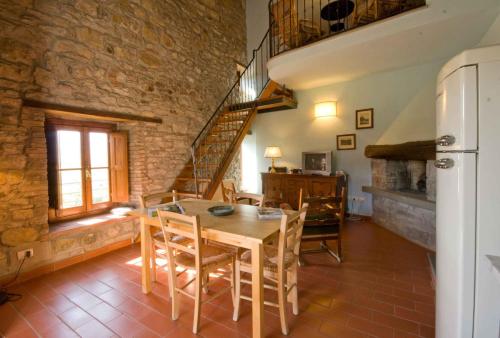 une salle à manger avec une table en bois et un mur en briques dans l'établissement Gli Orzali, à Firenzuola