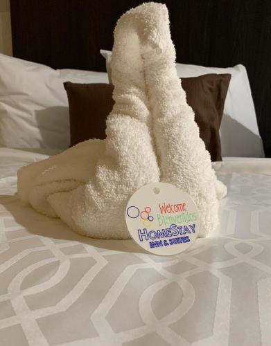 a white towel on a bed with a sign on it at HomeStay Inn & Suites Edinburg in Edinburg