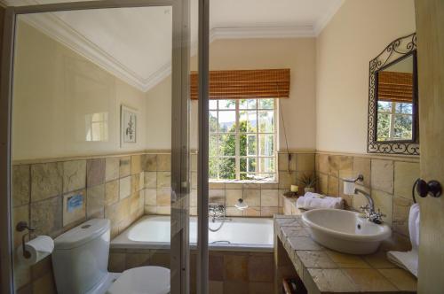 ein Badezimmer mit einer Badewanne, einem WC und einem Waschbecken in der Unterkunft San Rock Guest House in Clarens