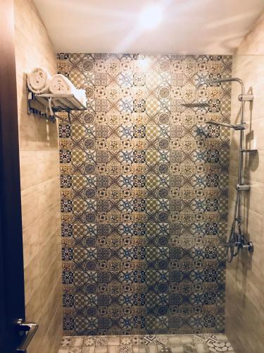 a bathroom with a shower with a tiled wall at Chemodann Kazbegi in Stepantsminda