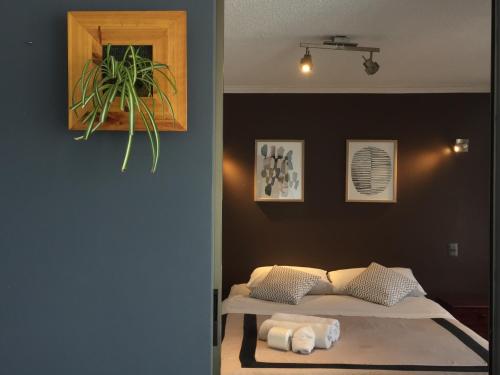 a bedroom with a bed and a plant on the wall at Espacio Norte Familiar - Cavancha in Iquique