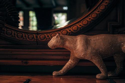 a statue of a dog standing in front of a mirror at Hôtel des Deux Clefs in Turckheim
