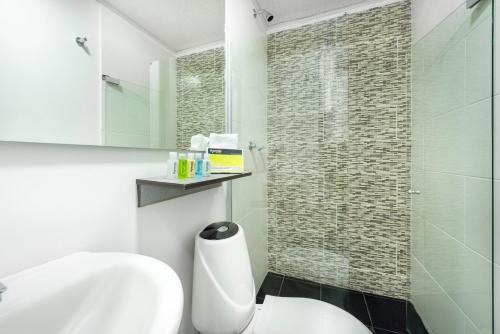 a bathroom with a white toilet and a shower at Ayenda 1024 Agora Inn Hotel in Bogotá