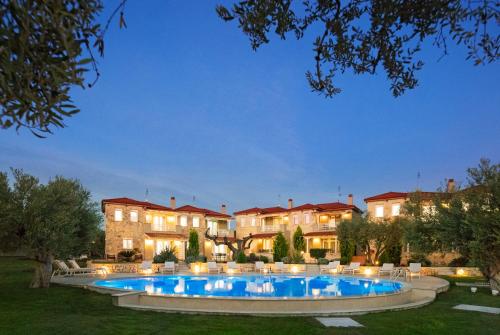 an estate with a swimming pool in front of a building at Kassandra Villas in Hanioti