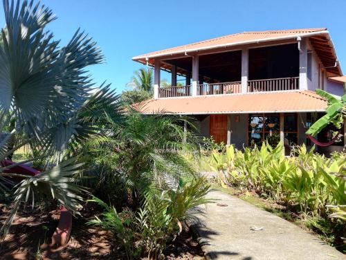 a house on the beach with palm trees in front at Punta Duarte Garden Inn in Los Duarte