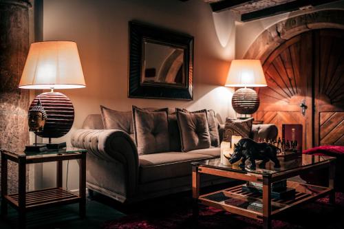 a living room with a couch and a table with lamps at Hôtel des Deux Clefs in Turckheim