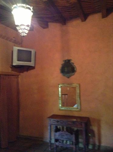 パツクアロにあるMeson de San Antonioの鏡と壁掛けテレビ付きの部屋