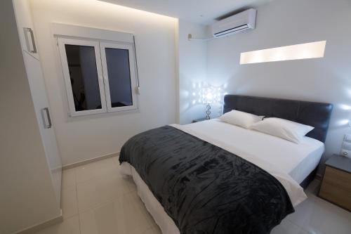 biała sypialnia z dużym łóżkiem i oknem w obiekcie White Lux Apartment For 2 VIPGreece w Atenach