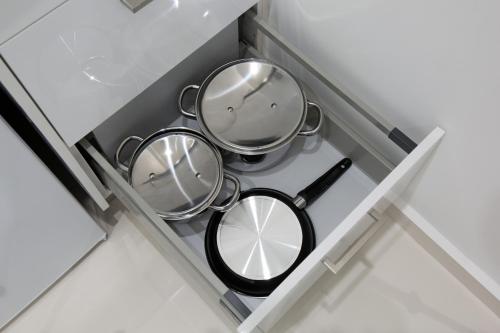 dwie patelnie w szufladzie w kuchni w obiekcie White Lux Apartment For 2 VIPGreece w Atenach