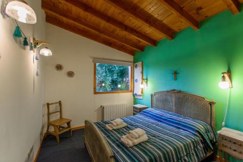 1 dormitorio con 1 cama con toallas en Casa Las Lilas en Villa La Angostura