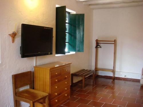 a living room with a dresser and a flat screen tv at Hotel Hospederia San Carlos Villa De Leyva in Villa de Leyva