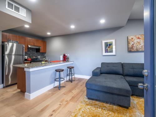 Una sala de estar con un sofá y una cocina. en Verandas at Uptown, en Austin