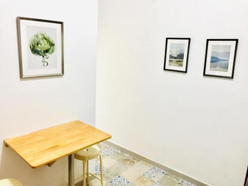 バジェ・グラン・レイにあるEfigenia playa/mar 1の壁に3枚の絵が飾られたテーブル付きの部屋