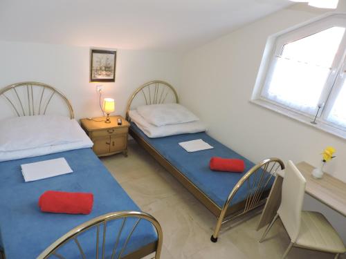 a bedroom with two beds and a desk and a table at Noclegi Mączyńskiego in Jarosław