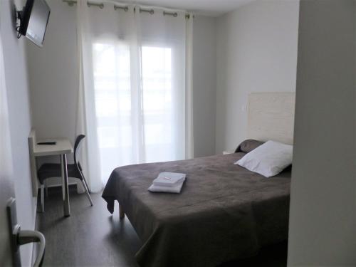 a bedroom with a bed and a desk and a window at Actif Residence in La Grande-Motte
